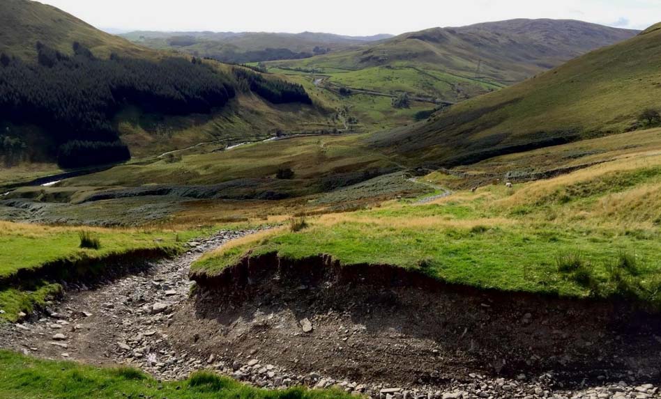 Eroded path across a grassy valley