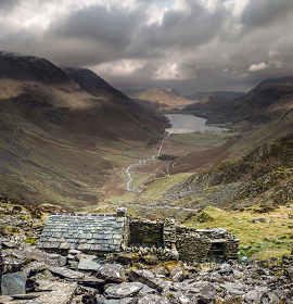 a view of the back of Warnscale Bothy and  Buttermere beyond