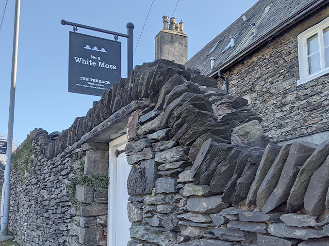 Stone wall with a property entrance gateway inset.