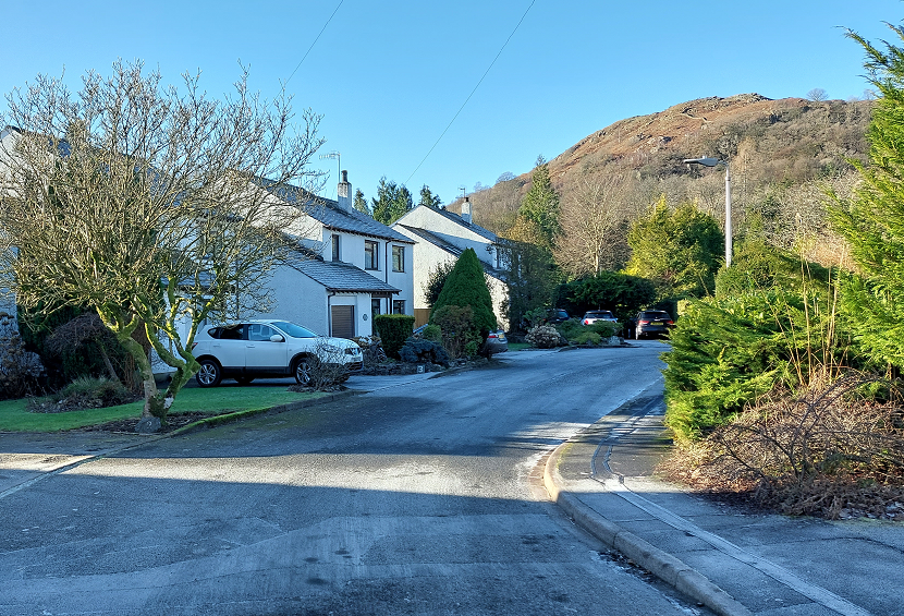 The view of the hillside is an attractive terminal feature of this  suburban street. Ambleside.
