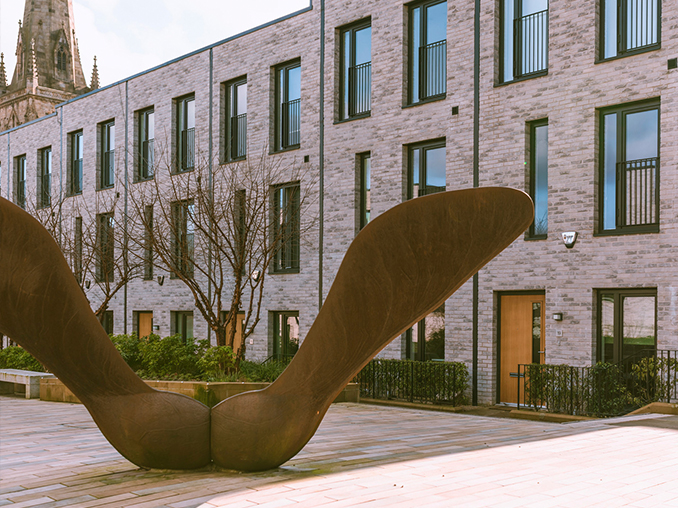 Metal statue in a city pedestrian area.