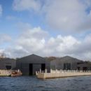 A view of teh new Windermere Jetty Museum taken from WIndermere with eth sjy in the background 