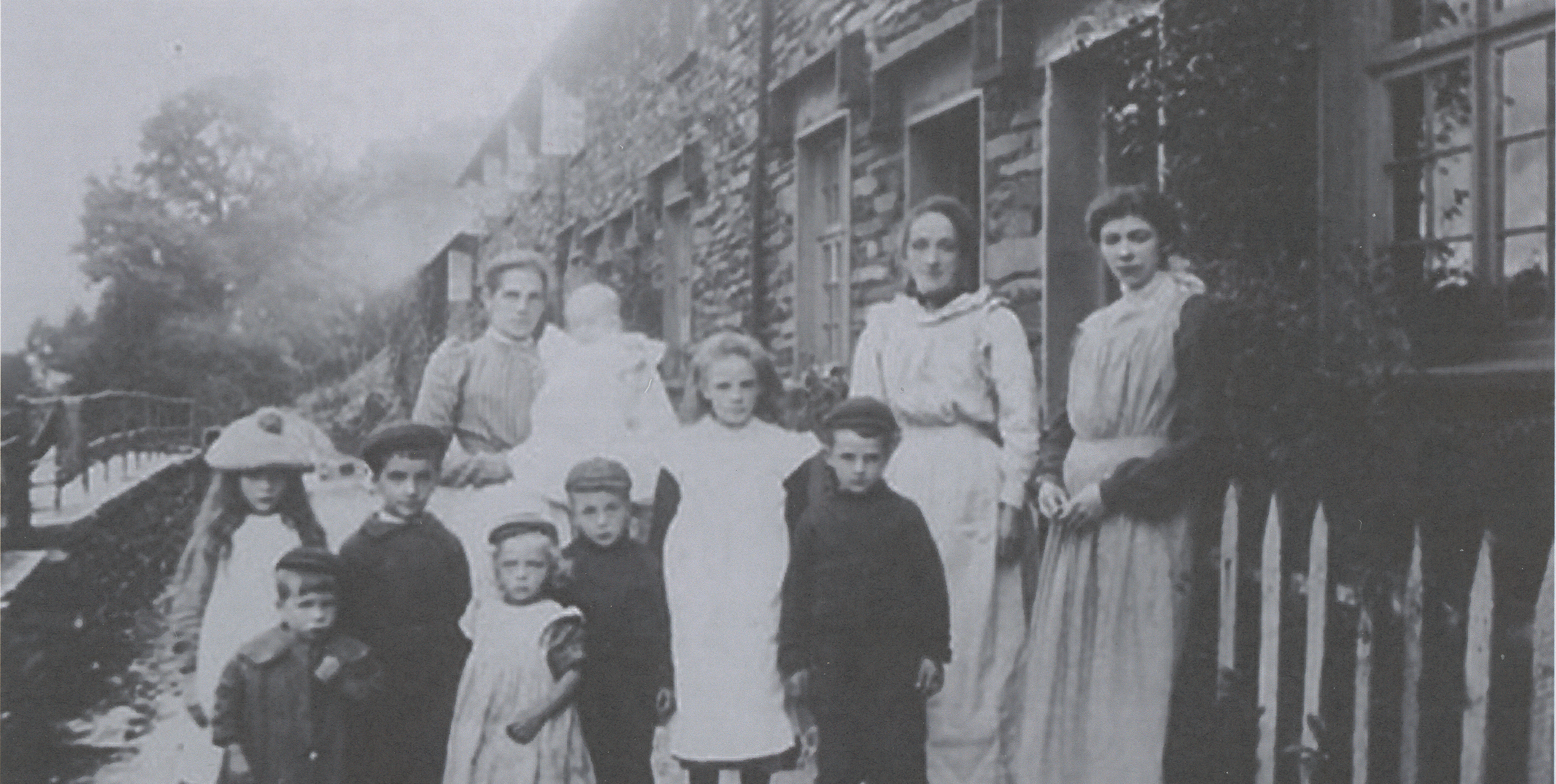 Historic photograph of residents outside Cat Bank, a terrace built for miners by the Coniston Copper Mine company.