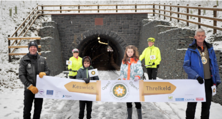 Official opening of Keswick to Threlkeld in the snow with a banner, snow, National Park staff and public