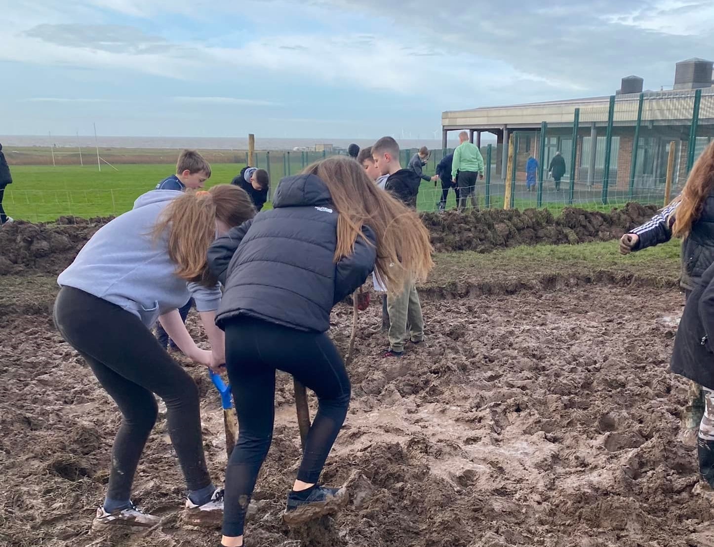 Two girls digging as part of an outdoor lesson at Walney School