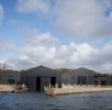 A view of teh new Windermere Jetty Museum taken from WIndermere with eth sjy in the background 