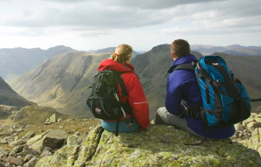 Scafell Pike in background - two walkers sat looking across at it