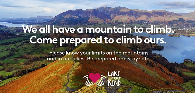Text over a fell in the Lake District: We all have a mountain to climb, come prepared to climb our. Lake District Kind.