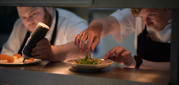 Chef's plating up dishes on the pass