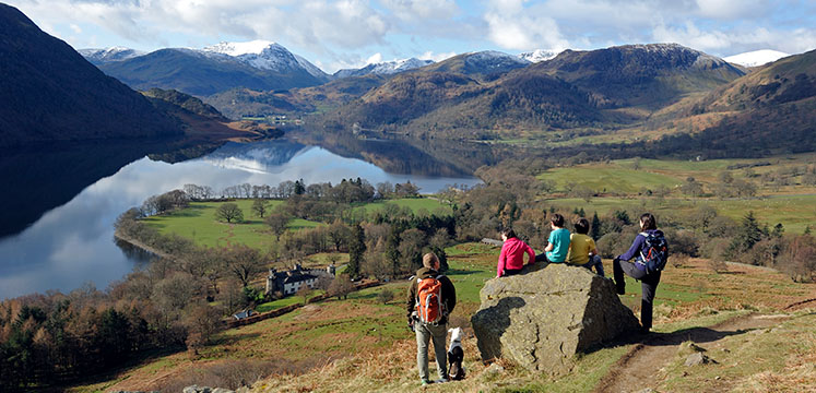 Family group taking a rest and enjoying the view over Ullswater with fells in the distance