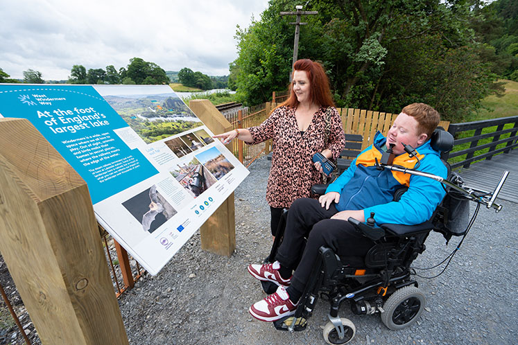 West Windermere Interpretation - Wheelchair user reading interpretation board