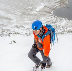 Fell Top Assessor Zac Poulton on Helvellyn with Red Tarn in the background 