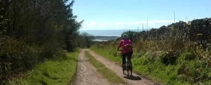 Connie on her ebike travelling along a path in the Western Lakes