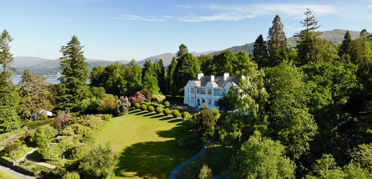 A grand country house in large gardens on the edge of Lake Windermere