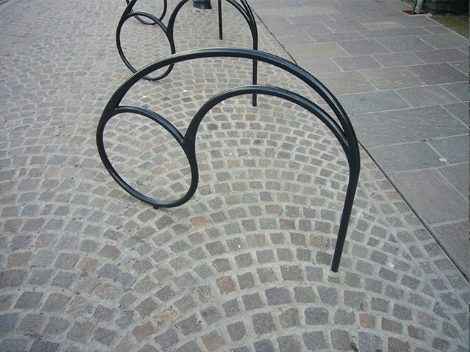 Iron work cycle parking on a cobbled surface.